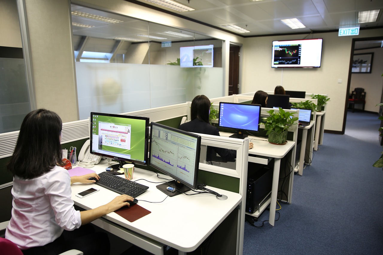 A group of people sitting at computers in an office.